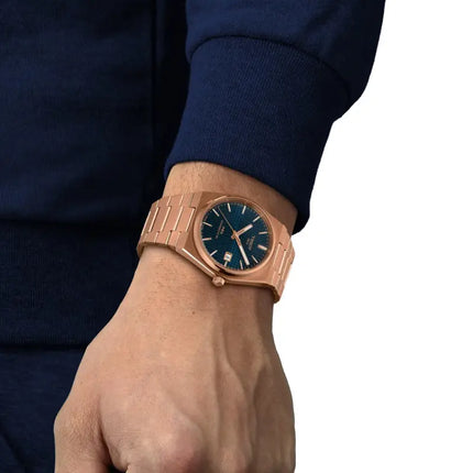 Vista en la muñeca del reloj Tissot PRX Powermatic 80 de 40 mm en acero con PVD oro rosa